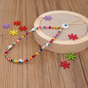 Detail of beaded phone strap with colorful clay beads and protective evil eye charm