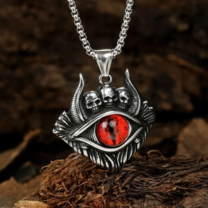 Macro shot of silver titanium pendant featuring a red eye and triple skulls