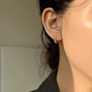 Minimalist 925 sterling silver golden spiral twist hoop earrings on model ear