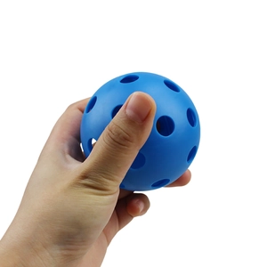 Blue 72mm indoor pickleball with 26 holes held in hand for size comparison