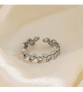 Detailed view of silver leaf pattern ring on elegant champagne silk fabric background