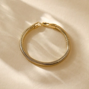 Detail of 14K gold plated snake chain bracelet with elegant sunlight shadow effect