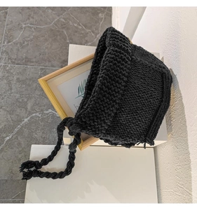 Détail du tissage en maille épaisse et des lanières tressées du bonnet d'hiver noir