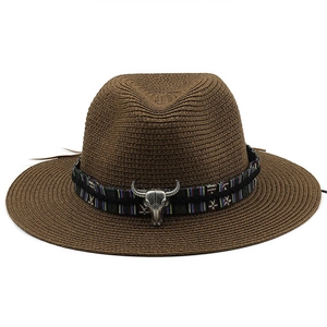 Detail of western straw fedora featuring a tribal band and silver bull skull ornament