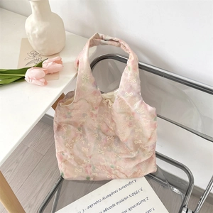 Detail of pink floral tote bag with delicate white bow embroidery and sheer tulle overlay