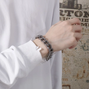 Detailed close-up of retro silver skull chain bracelet with intricate floral engravings