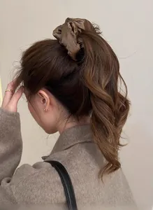 Detailed close-up of dark brown satin oversized scrunchie on a high ponytail