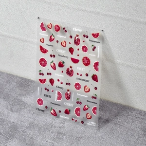Detail showing translucent 5D nail art stickers with realistic cherry and strawberry patterns