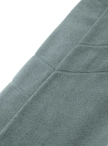 Dettaglio macro della trama in pile grigio antracite e delle cuciture resistenti