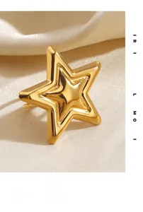 Macro close-up of polished gold star ring on elegant warm white satin background
