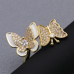 Macro shot of double butterfly ring with gold plating, white enamel and cubic zirconia