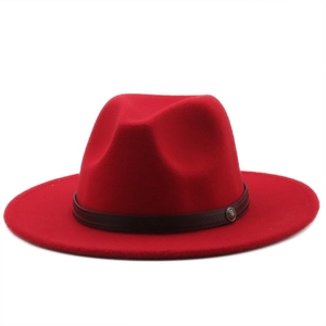 Detail of red wool fedora featuring a dark brown leather band and antique metal badge