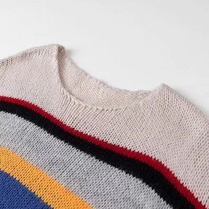 Close-up of the round neckline on a chunky knit sweater with colorful rainbow stripes