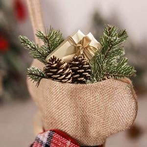 Christmas burlap reindeer bag with pine cones, needles, and a gold gift box decoration