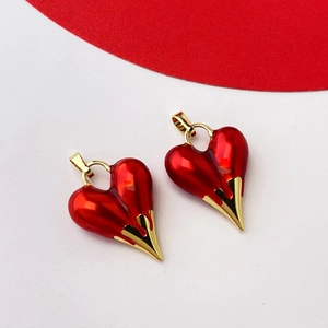 Close-up of red heart charms with gold dripping detail and metal hanging loops