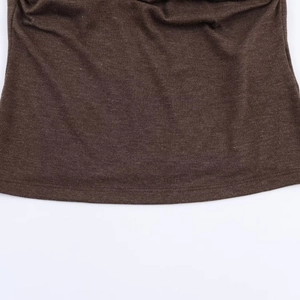 Close-up of brown knitted fabric texture and fine stitching on the garment hemline