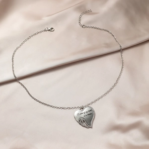 Detailed view of silver heart wing pendant with engraving A piece of my heart is in heaven
