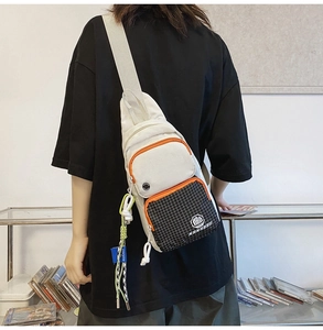 Detail of street style crossbody chest bag featuring cream beige fabric and black plaid pocket