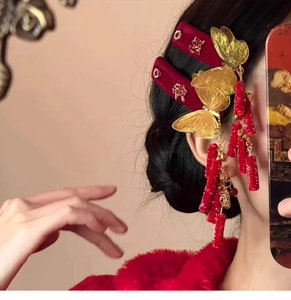 Detail of red velvet hair clip with golden butterfly, tassels and Xi character