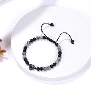Detail of 6mm matte black stone beaded bracelet with heart projection pendant and woven cord