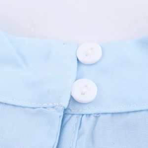 Close-up of light blue high neck shirt featuring white round buttons and fabric texture