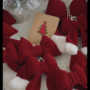 Red velvet Christmas bow with white faux fur trim and festive ornaments for home decoration