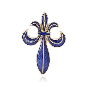 Golden and blue fleur-de-lis brooch with enamel texture on a white background