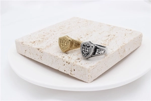 Detail view of gold and silver retro shield rings with cross relief on stone display