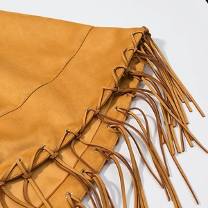 Ginger faux suede cape jacket with fringe details and metal eyelets on white background
