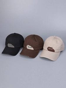 Close-up of distressed cotton baseball caps with RUN embroidery and frayed hole effects