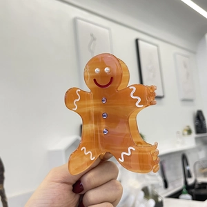 Cute gingerbread man hair claw clip in orange-brown acetate with purple rhinestones