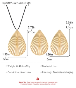Macro detail of golden metal leaf necklace and earrings with size measurements