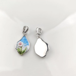 Detailed view of floral enamel pendant with silver base for pearl necklace DIY