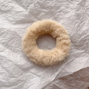 Detailed view of plush beige faux rabbit fur scrunchie with soft fluffy texture