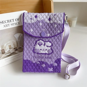 Detail of purple knitted crossbody phone bag with diamond pattern and cartoon character