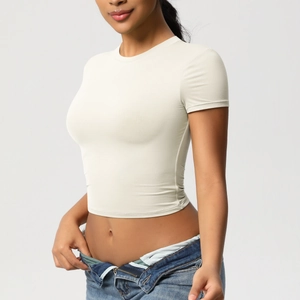 Side view of beige slim-fit crop top yoga shirt with moisture-wicking athletic fabric
