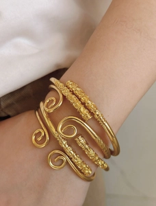 Detailaufnahme vergoldeter Armbänder mit Spiralmustern und Relief-Wolkenmotiven