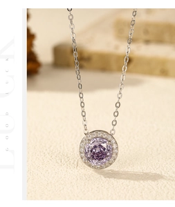 Gros plan d'un collier en argent s925 avec pierre violette taille rose et halo brillant