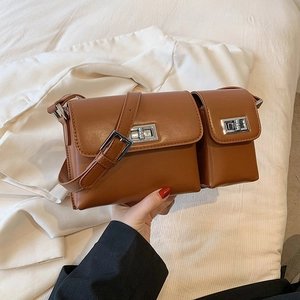 Detail of caramel baguette bag featuring silver twist lock and small matching pouch