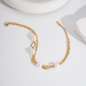 Double-layered gold stainless steel anklet with white pearls on a minimalist background