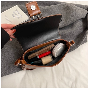 Interior view of brown punk stud shoulder bag showing capacity for phone and cosmetics