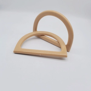 Close-up of a pair of D-shaped nude resin handles for DIY knitted handbag accessories