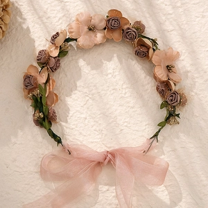Detailed top view of handmade floral headband with pink roses, green leaves and ribbon bow