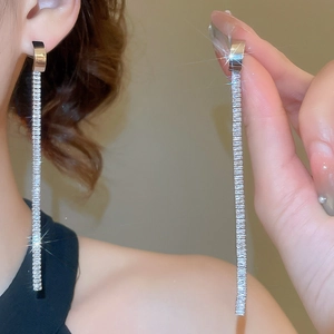 Detail of silver drop earrings with rectangular zircon tassels worn by a model