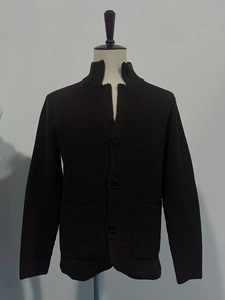 Detail of dark brown waffle knit cardigan with stand collar and three black buttons