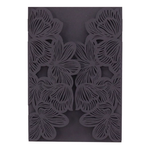 Macro detail of laser-cut black floral pattern on elegant wedding invitation cover