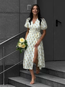 Detail of floral wrap dress featuring yellow tulips, puff sleeves and side slit design