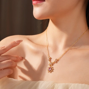 Detail of vintage flower necklace with pink oval gemstone on model neck