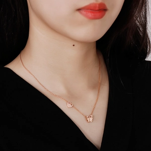 Detailed view of rose gold butterfly necklace with crystal inlay and heart charm