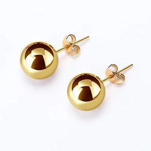 Boucles d'oreilles boules en acier inoxydable doré poli avec fermoirs papillon sur blanc